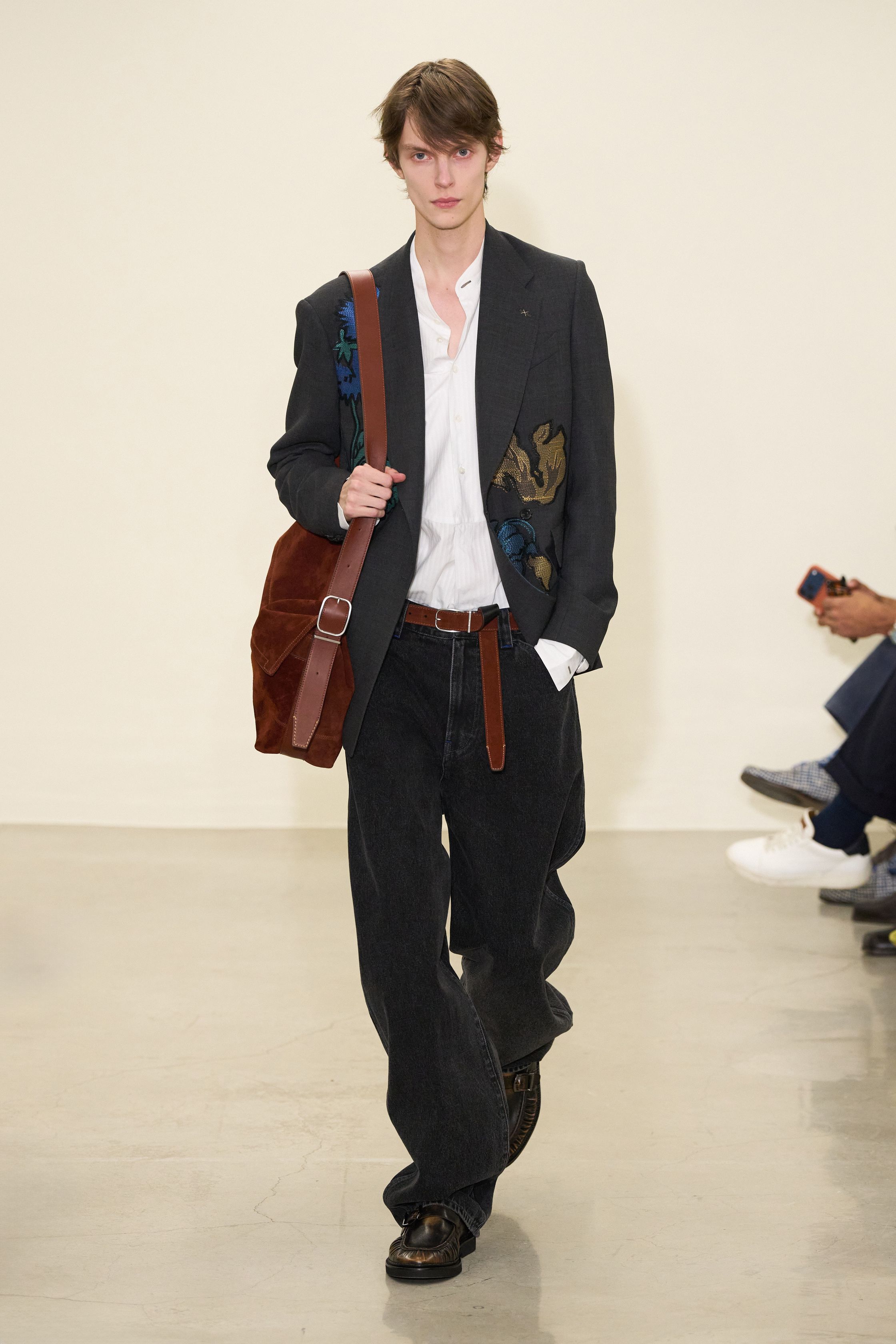 Paul Smith 2026秋冬回归品牌最具识别度的“英式日常诗意”。系列以传统剪裁为骨架，却通过色彩点缀、围巾叠搭与比例微调，赋予男装更松弛的情绪温度。西装不再严肃，风衣与大衣在肩线与长度上释放空间，搭配针织与衬衫形成轻度混搭。整体传递的是一种文化型男性的穿衣态度——不追逐潮流，却始终保持幽默感与个人风格-顽石频道趋势研究